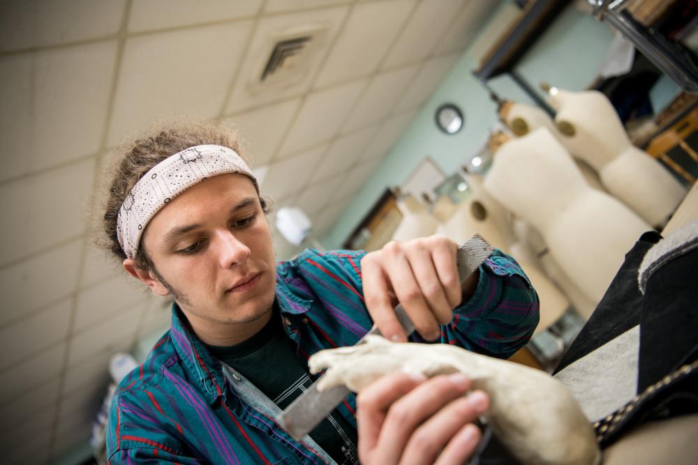 Student works on creating their costume in the costume shop for a 戏剧表演.